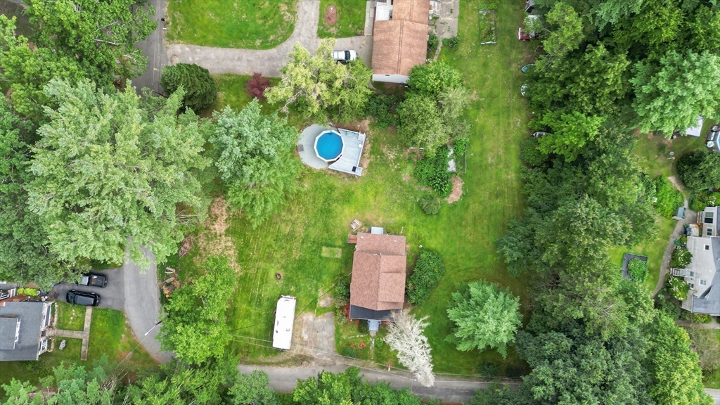 an aerial view of a house with a yard and trees