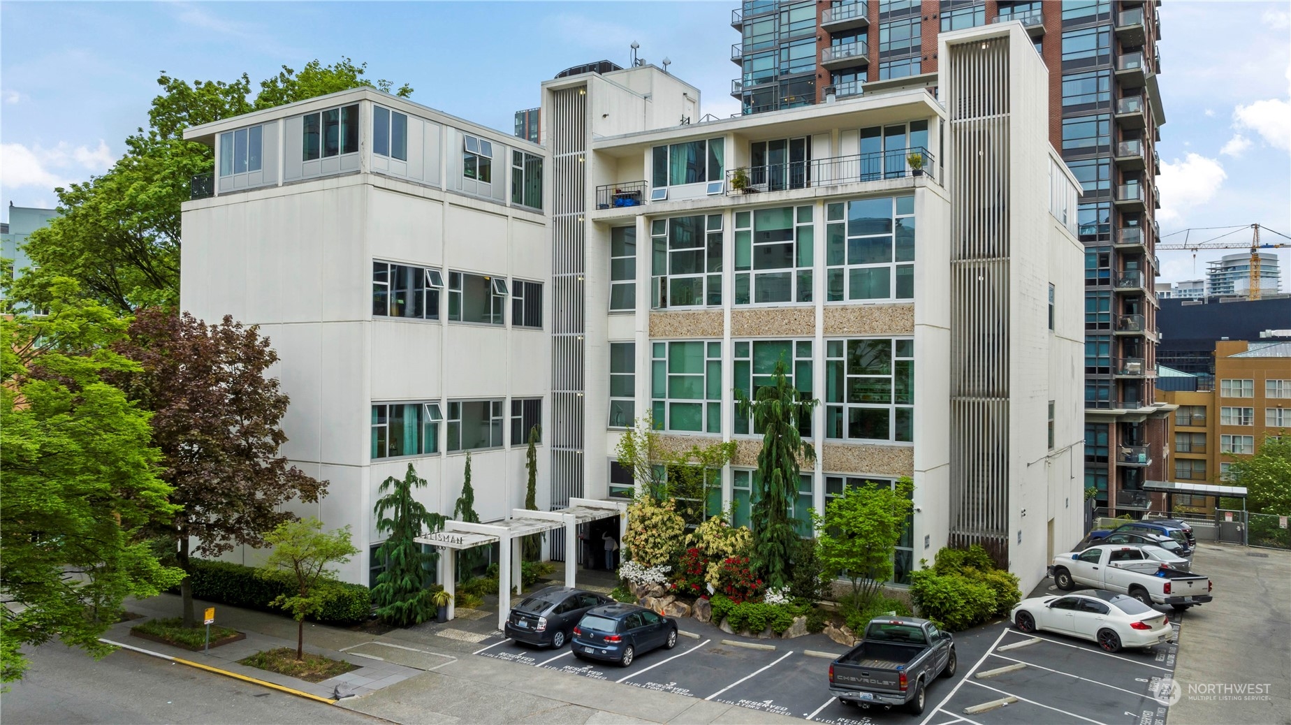 a front view of a building with a garden and plants