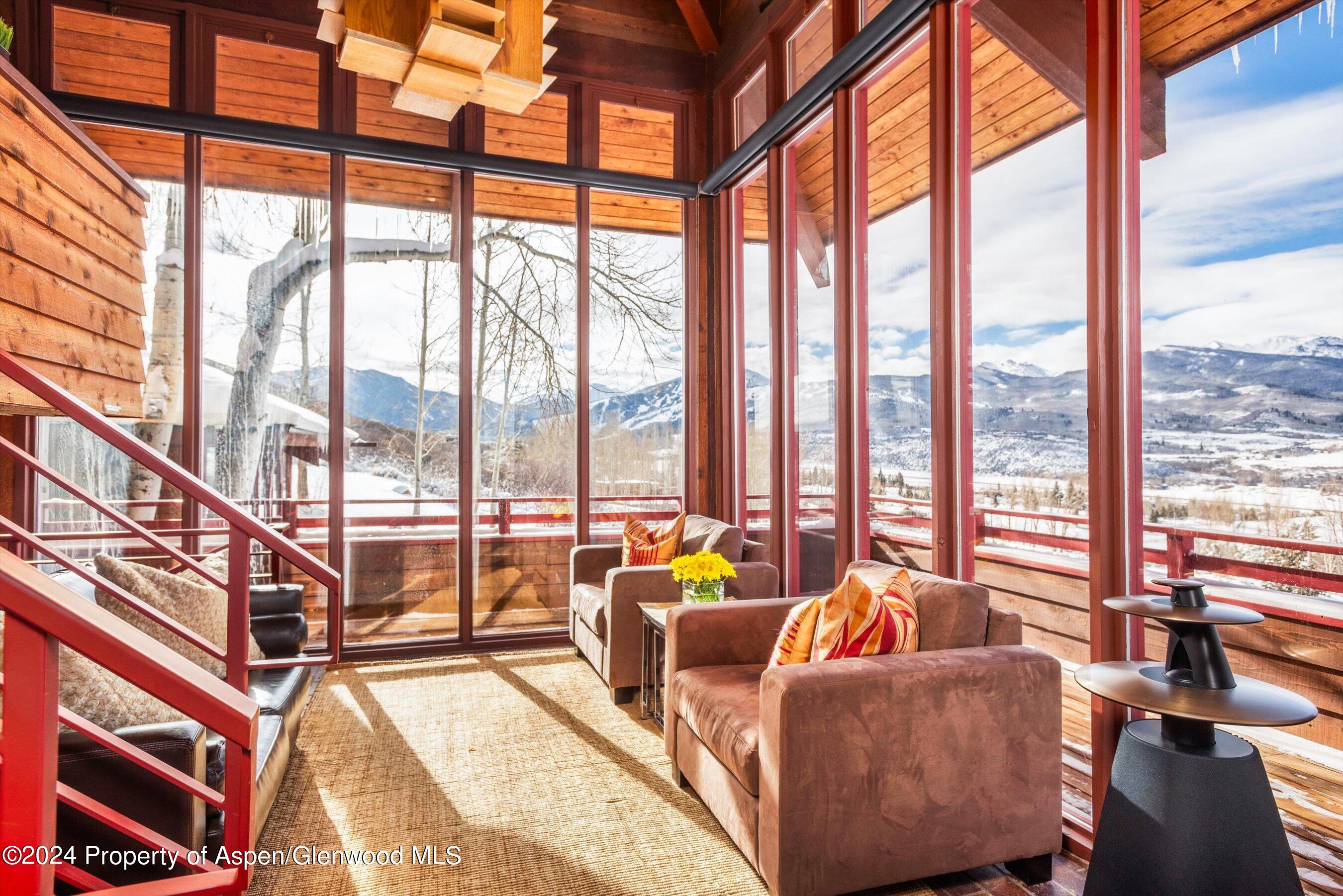 a living room with furniture and floor to ceiling windows