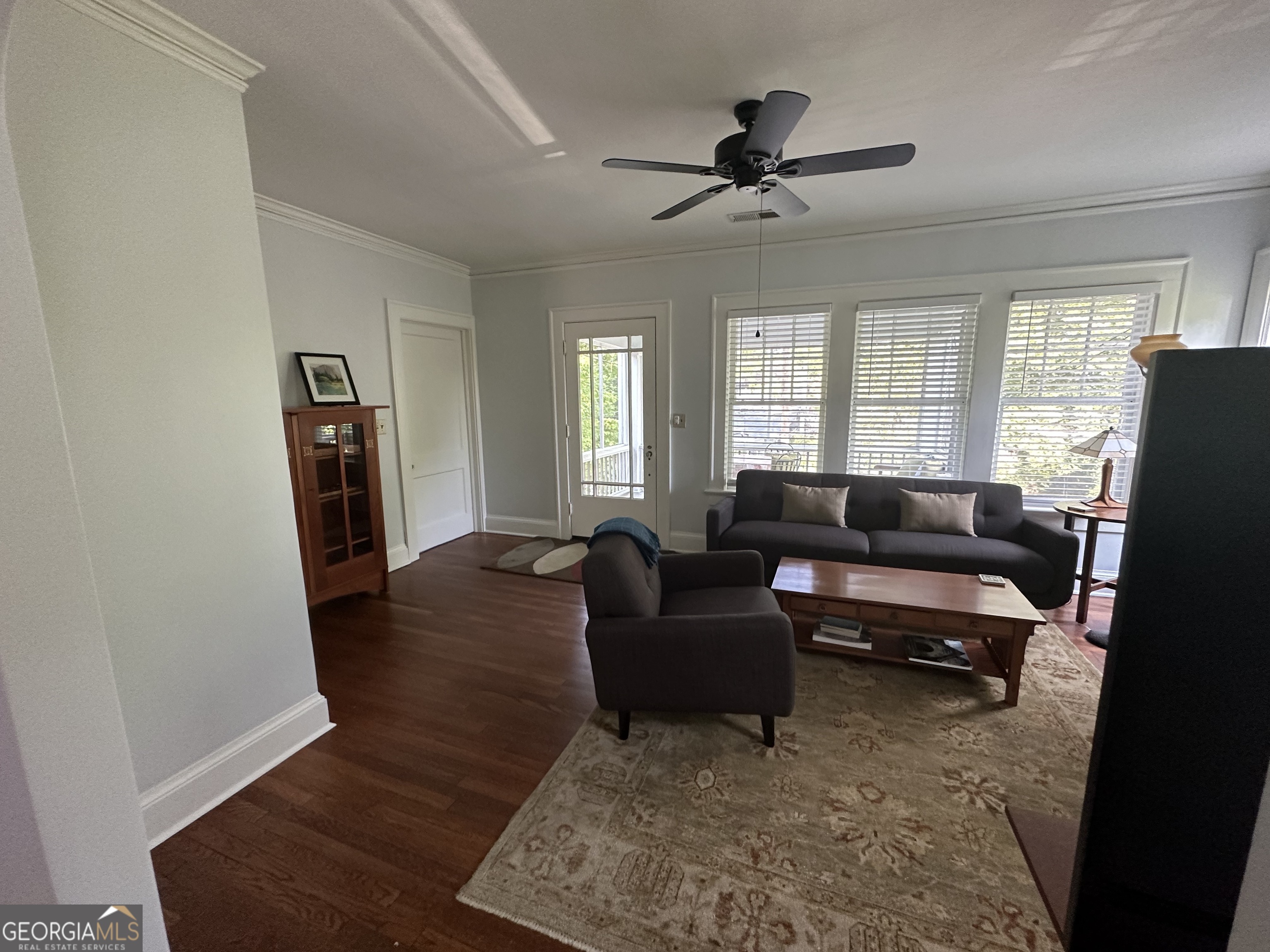 a living room with furniture and a wooden floor