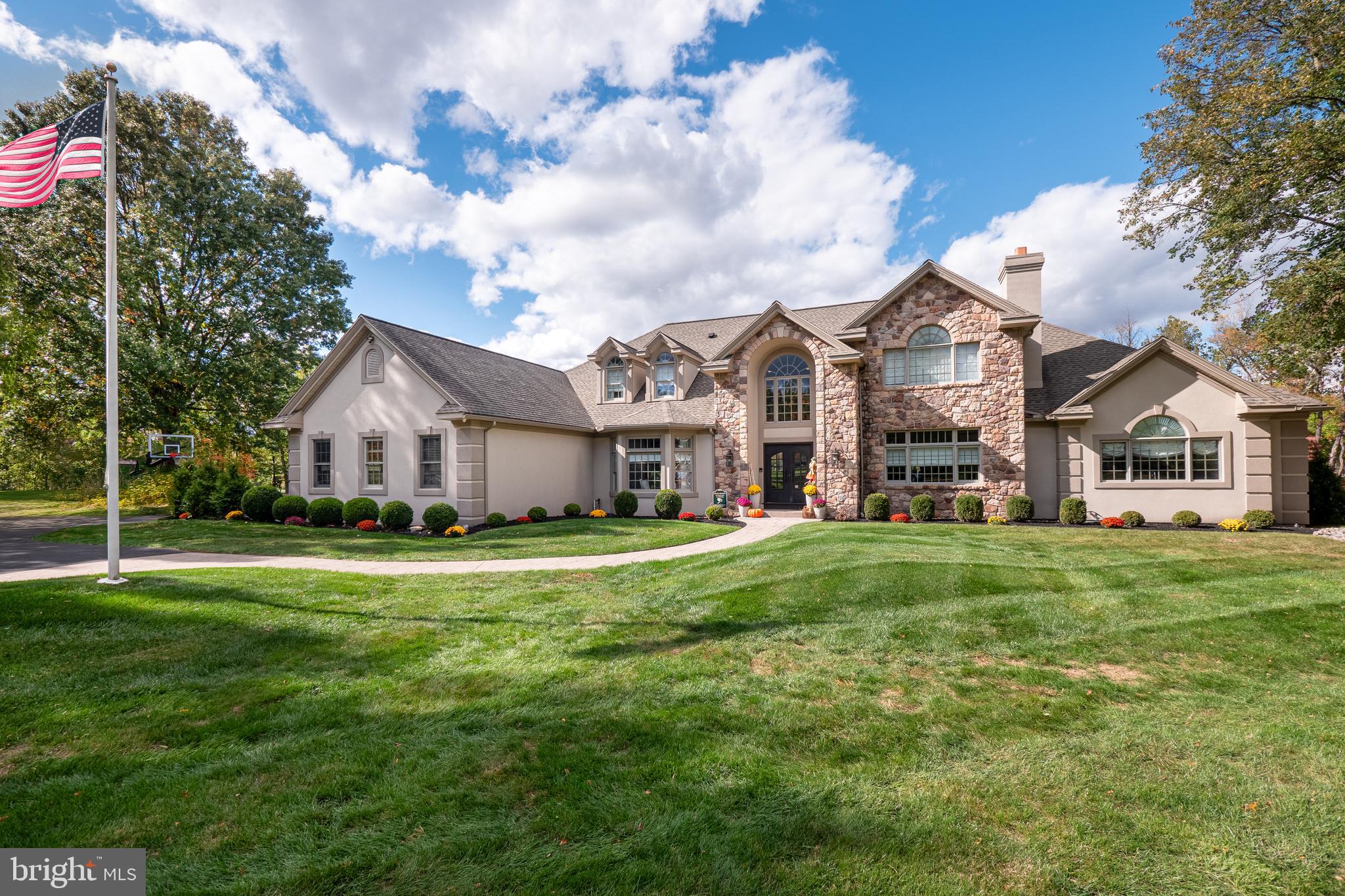 a front view of a house with a yard and trees