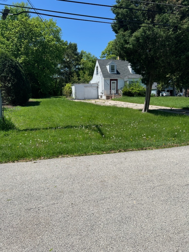 a front view of a house with a yard and trees