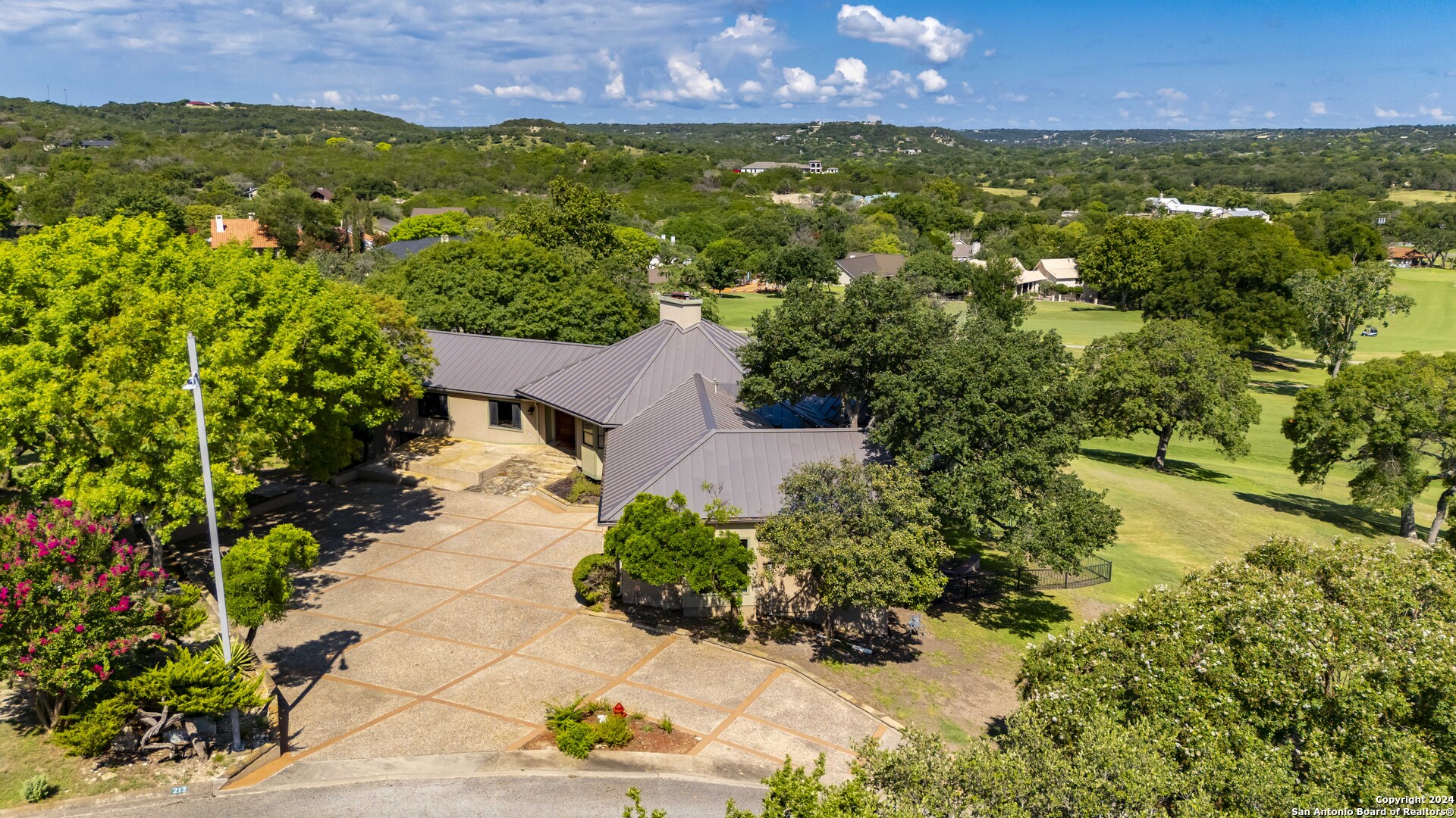 an aerial view of residential houses with outdoor space and trees