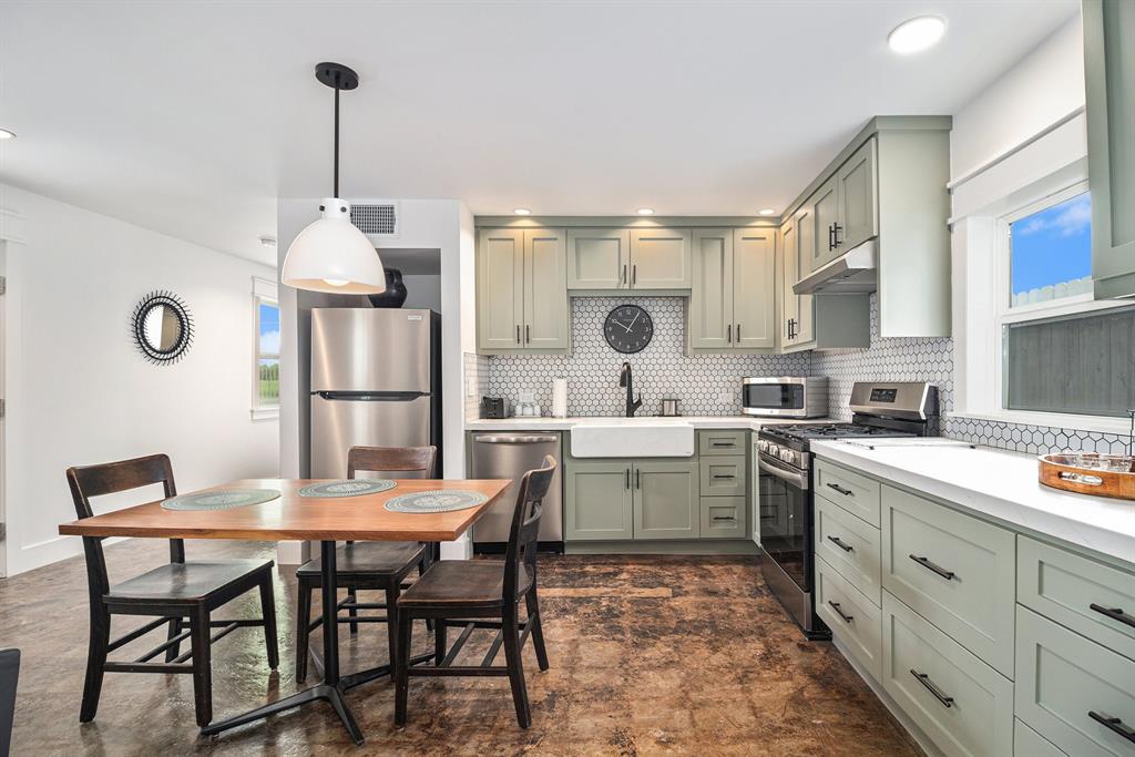 a kitchen with a dining table chairs and white cabinets