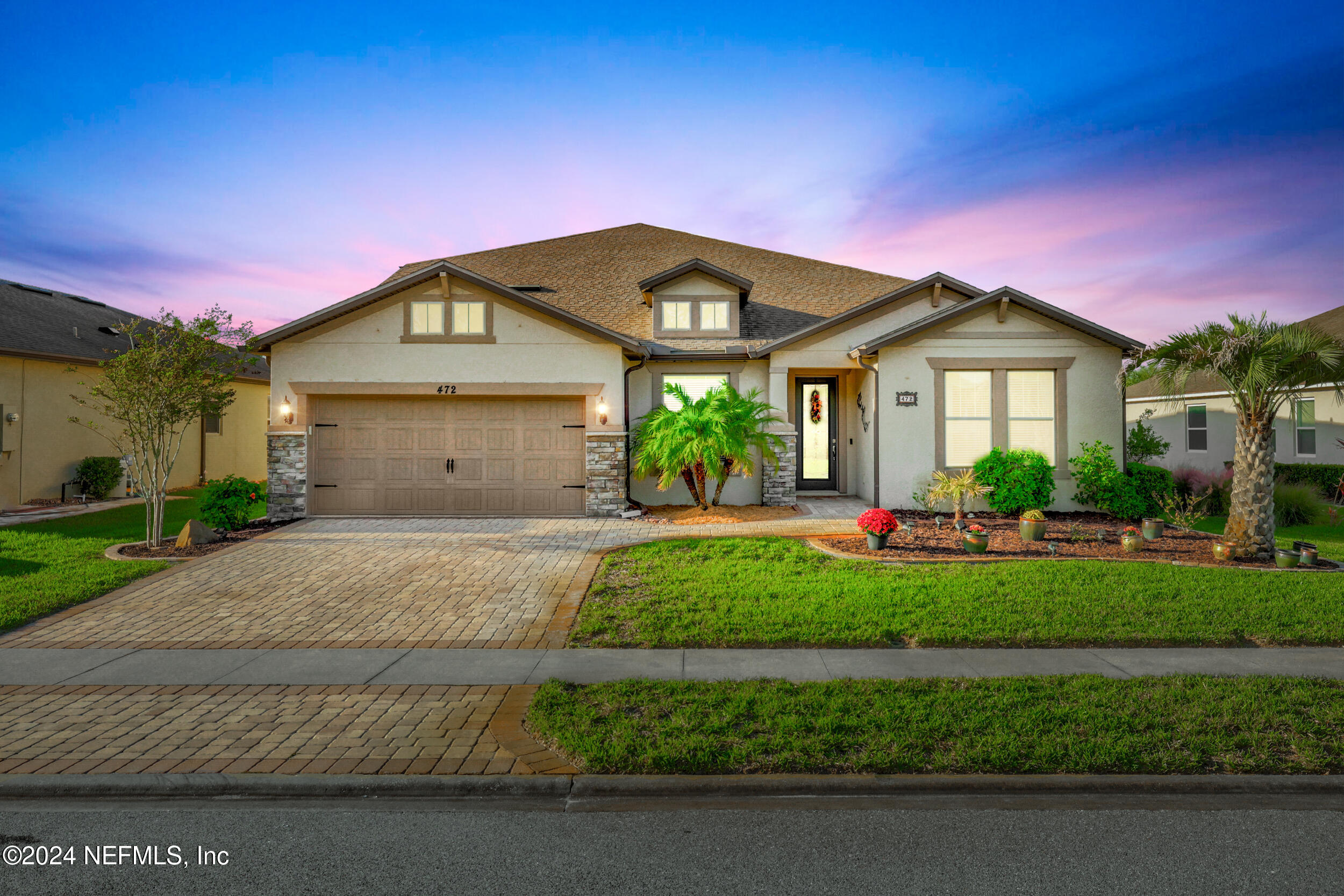 a front view of a house with a garden and yard