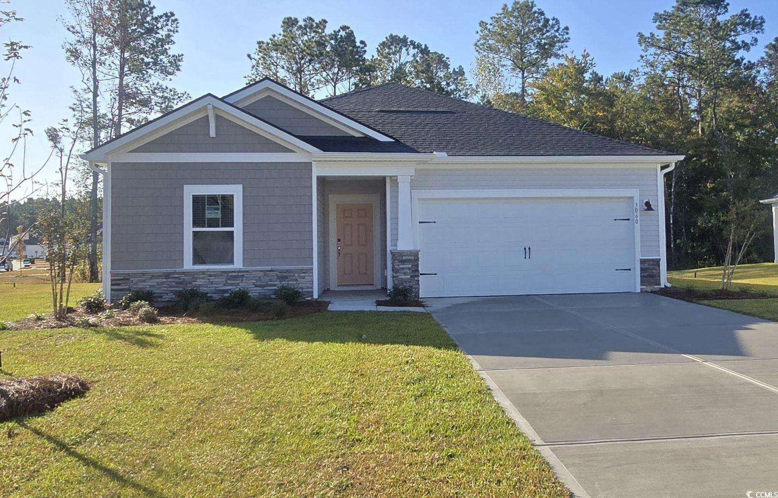 Craftsman house with a front lawn and a garage