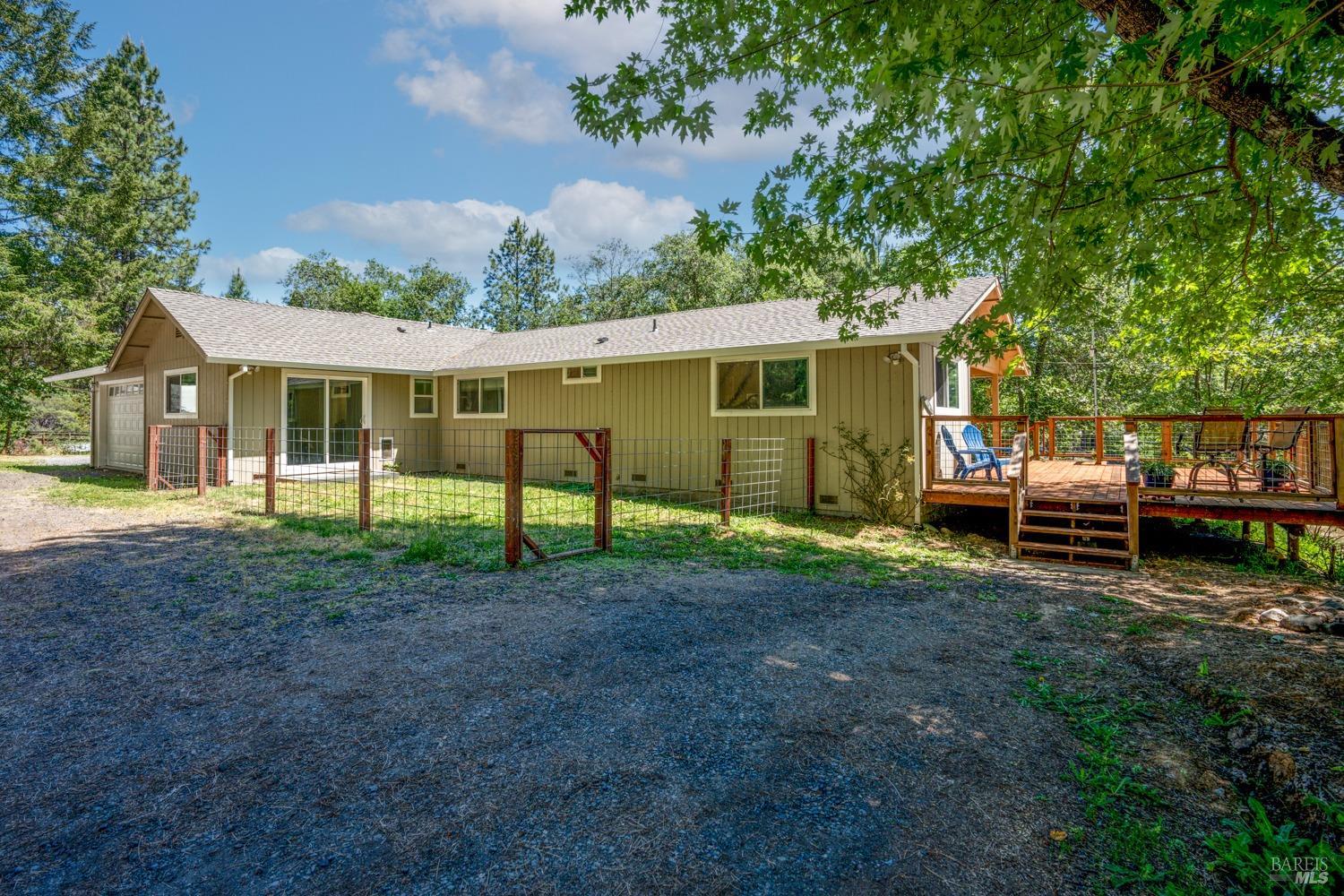 a view of a house with backyard and trees