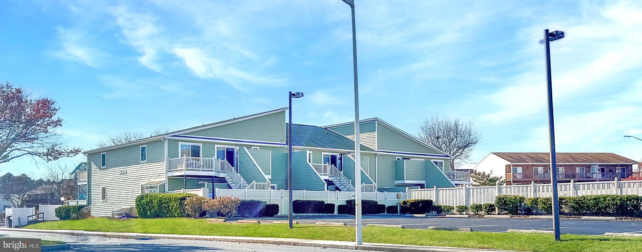 a front view of a building with street view and trees