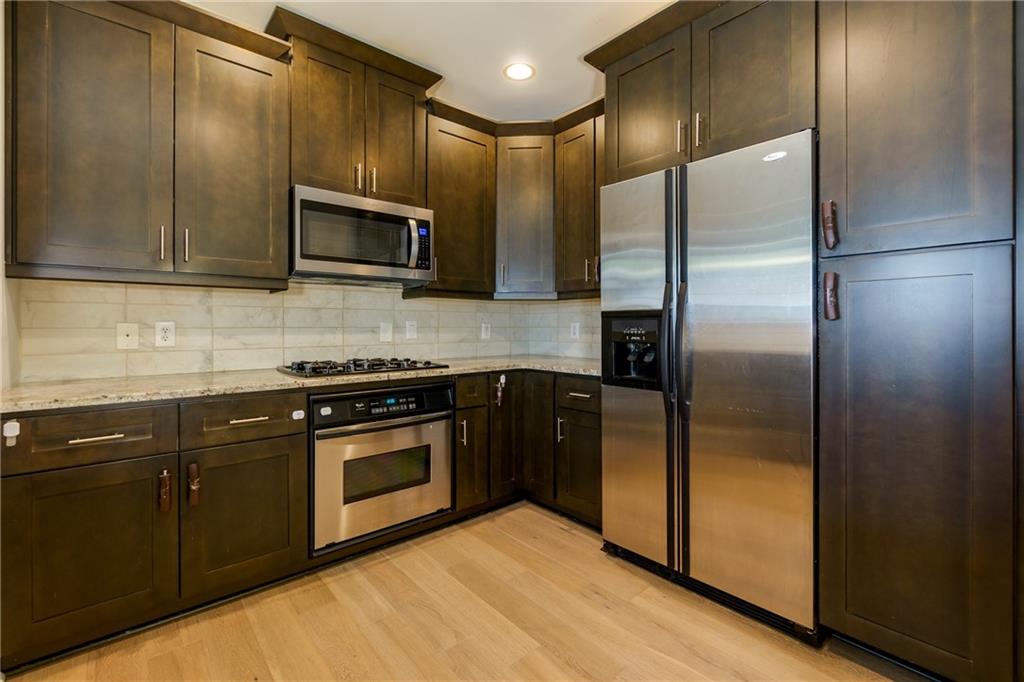 a kitchen with granite countertop a refrigerator and a sink