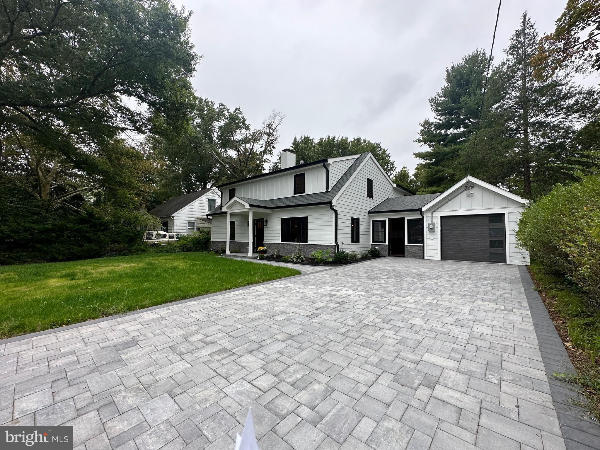 a front view of a house with a yard and trees