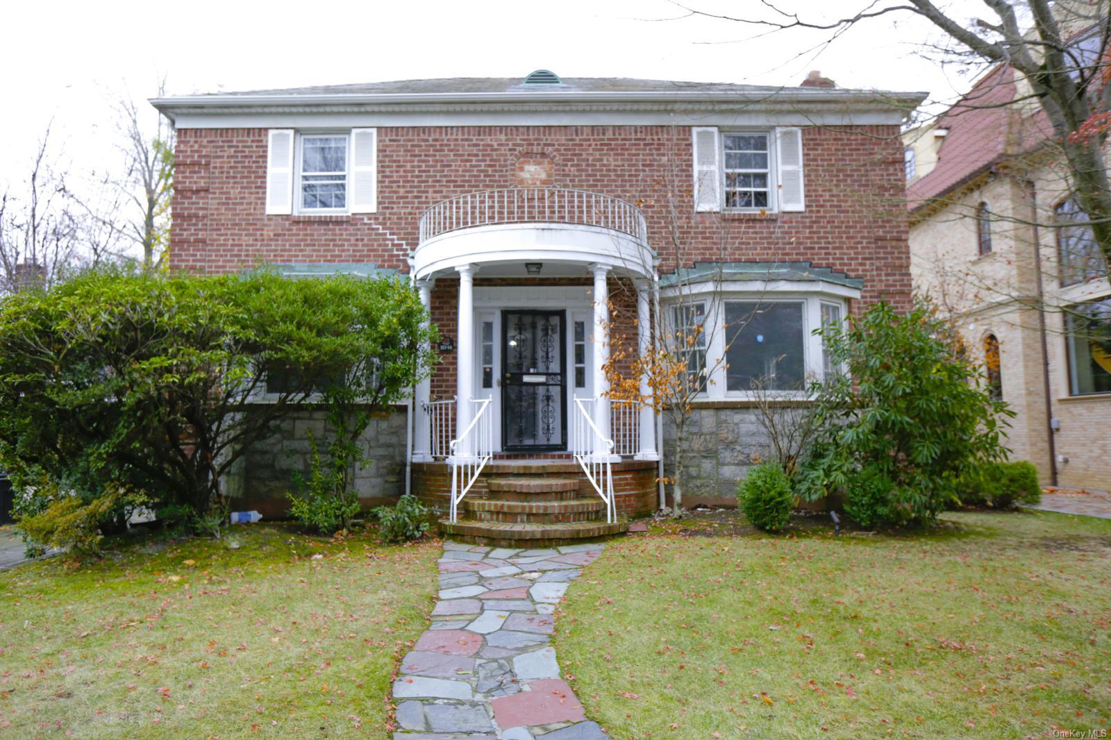 View of front facade featuring a balcony and a front yard