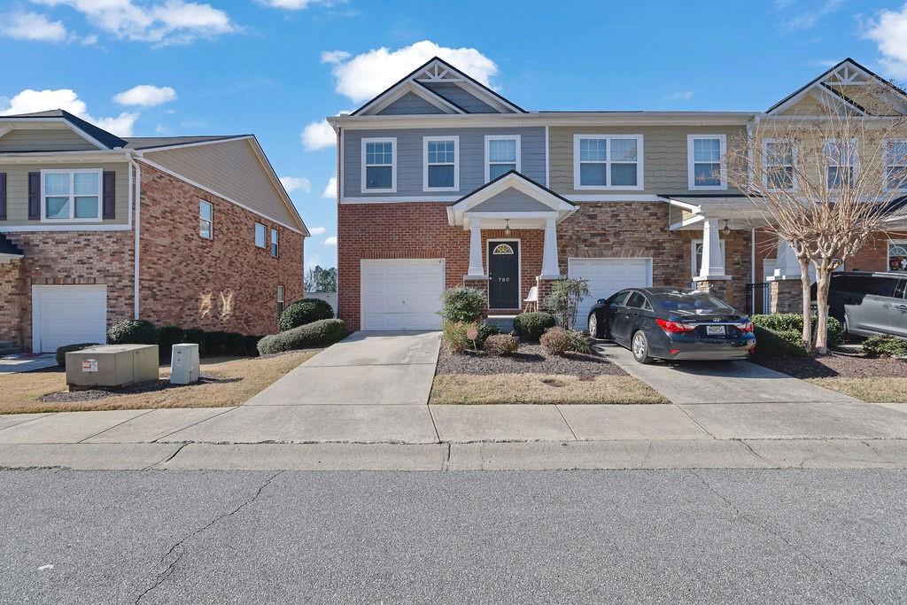 a front view of a house with cars parked