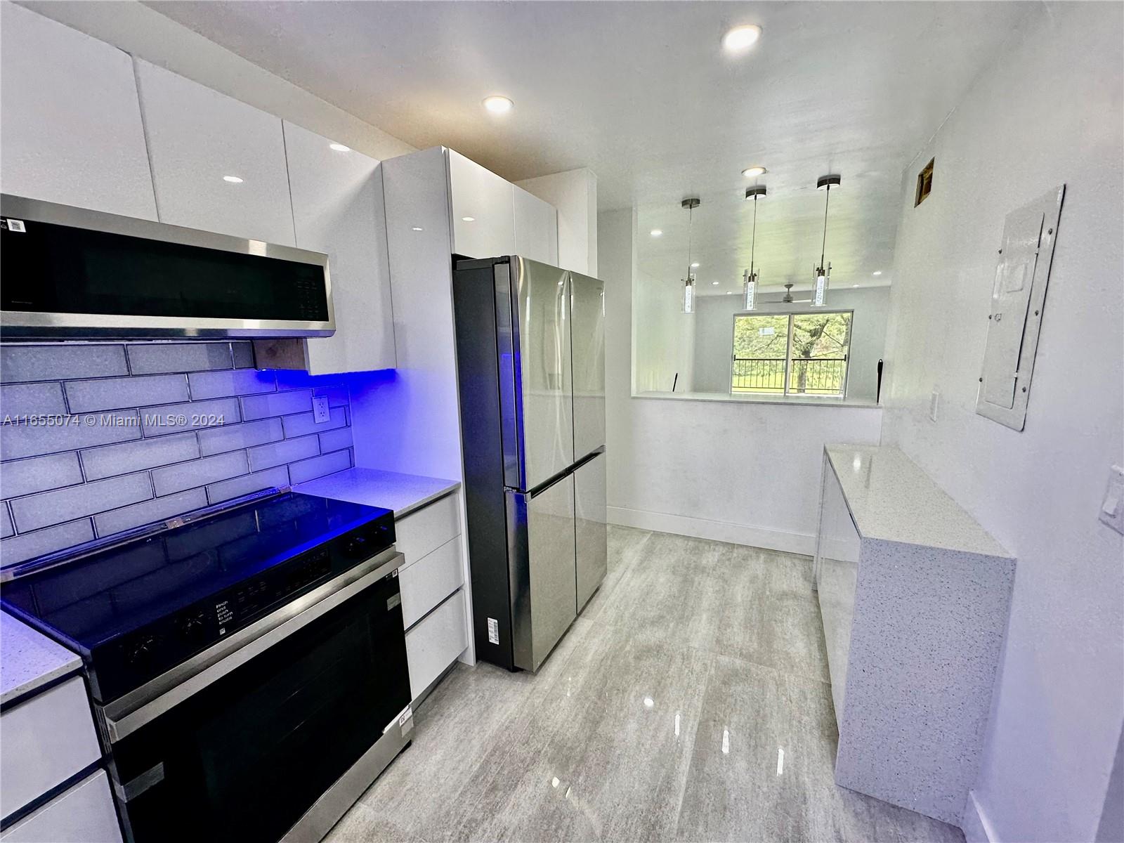 a kitchen with stainless steel appliances a stove a refrigerator and a microwave