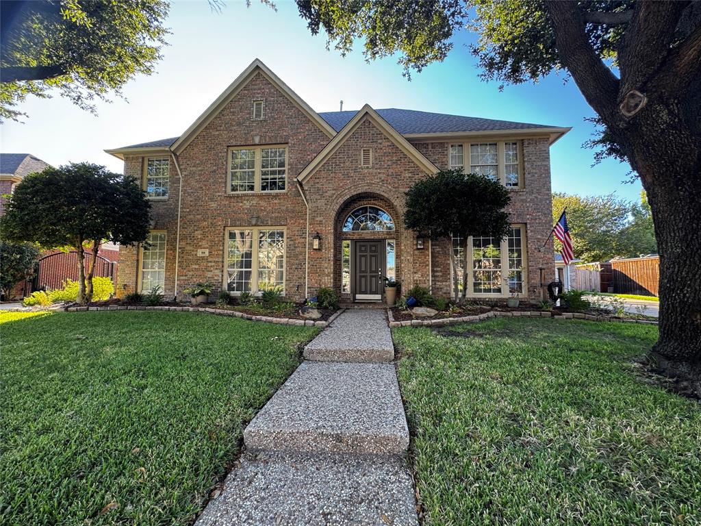 a front view of a house with a yard and garden