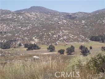 a view of a field with mountains in the background