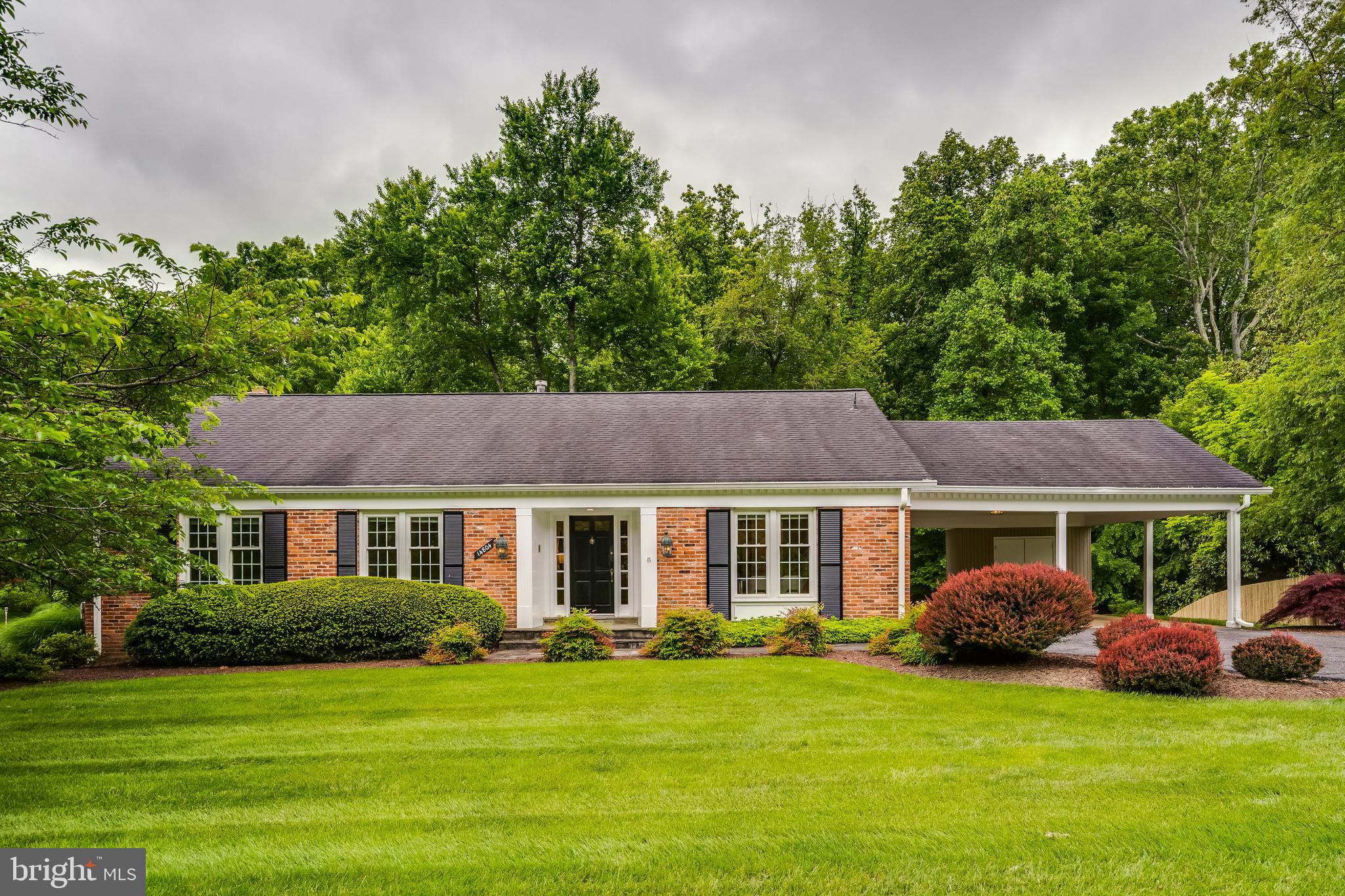 a view of a house with a yard and a large tree