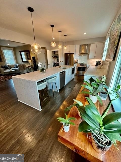 a living room with kitchen island granite countertop furniture wooden floor and a view of kitchen