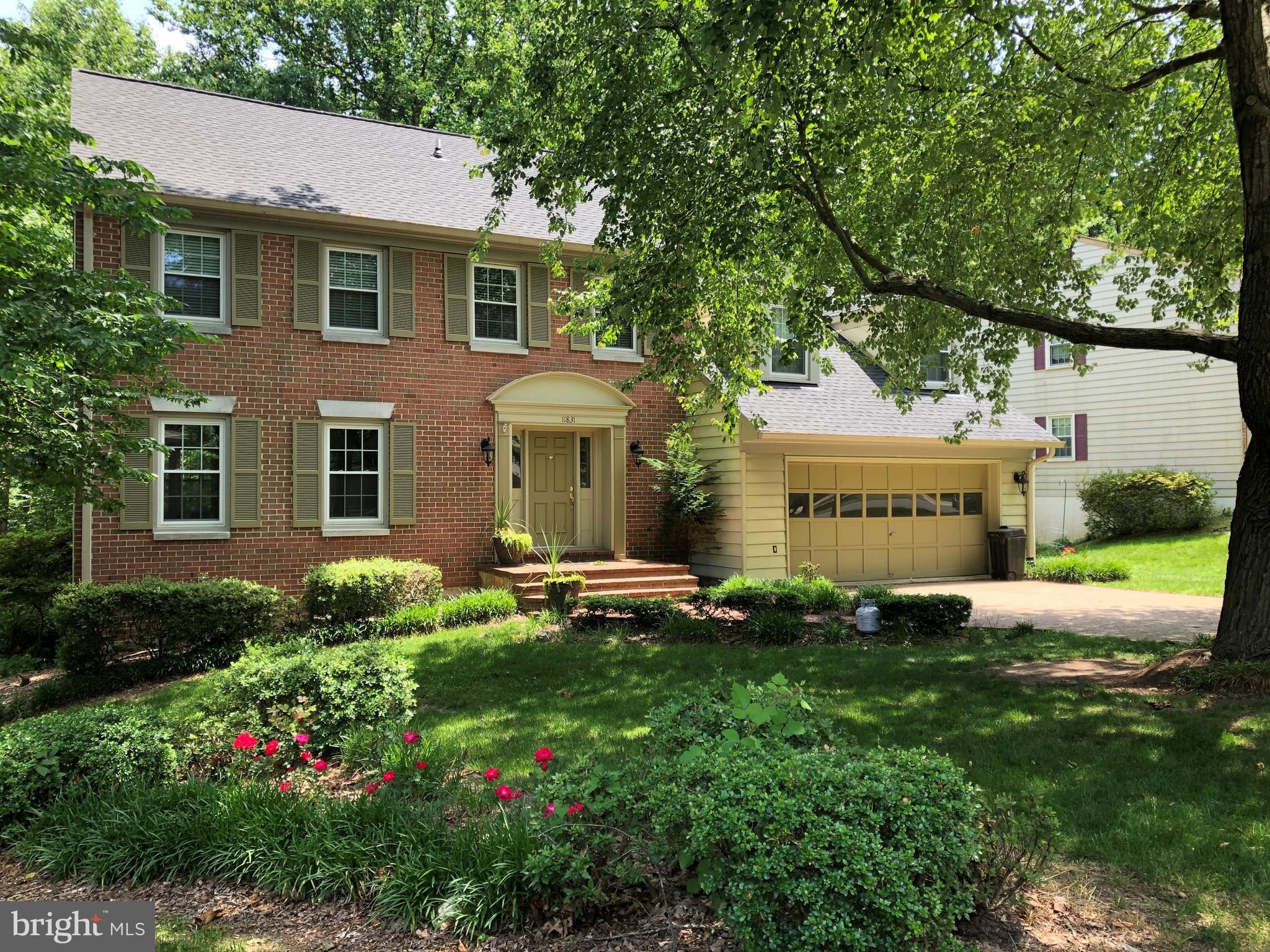 a front view of a house with a garden and plants