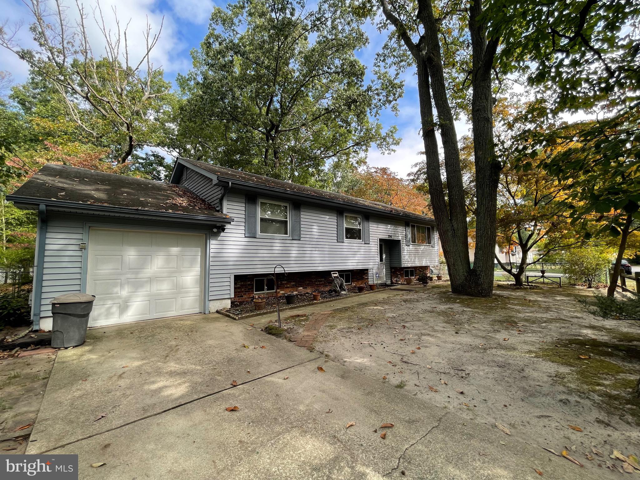 a view of a house with a backyard and tree