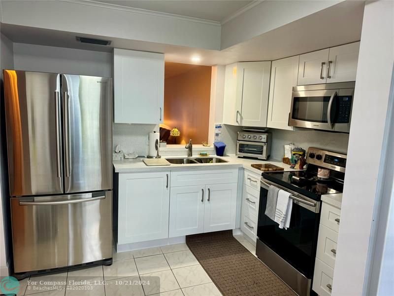 a kitchen with cabinets stainless steel appliances and a counter space