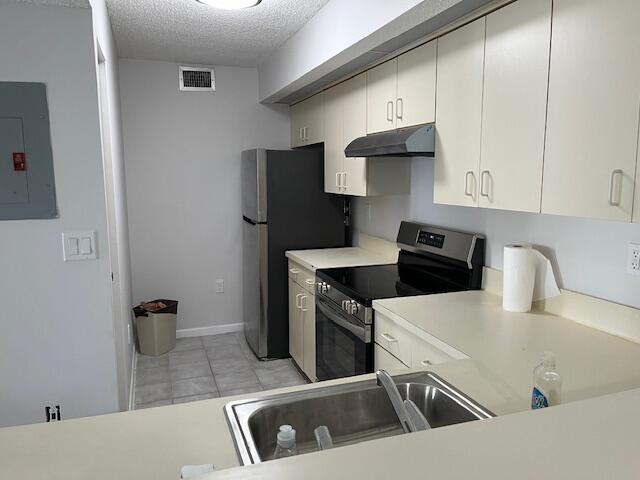 a kitchen with stainless steel appliances granite countertop a sink a stove and a refrigerator