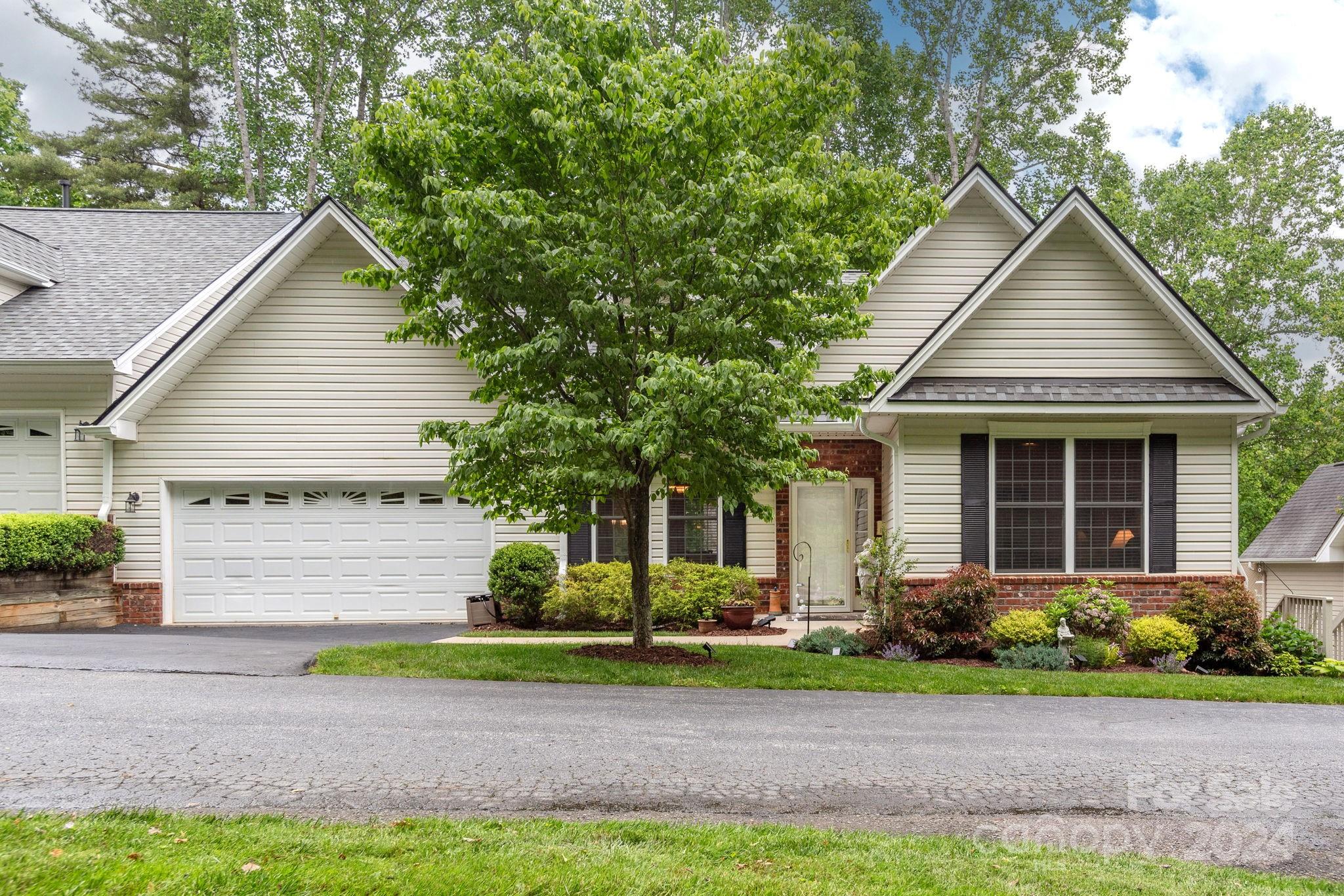 a front view of a house with a yard and plants