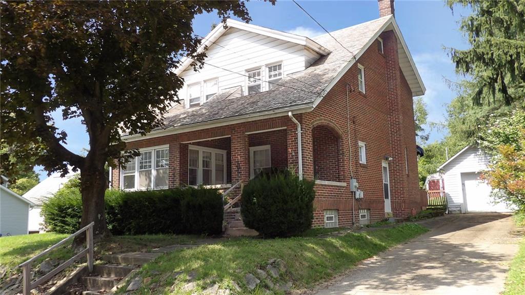 a view of a brick house with a large windows and a large tree