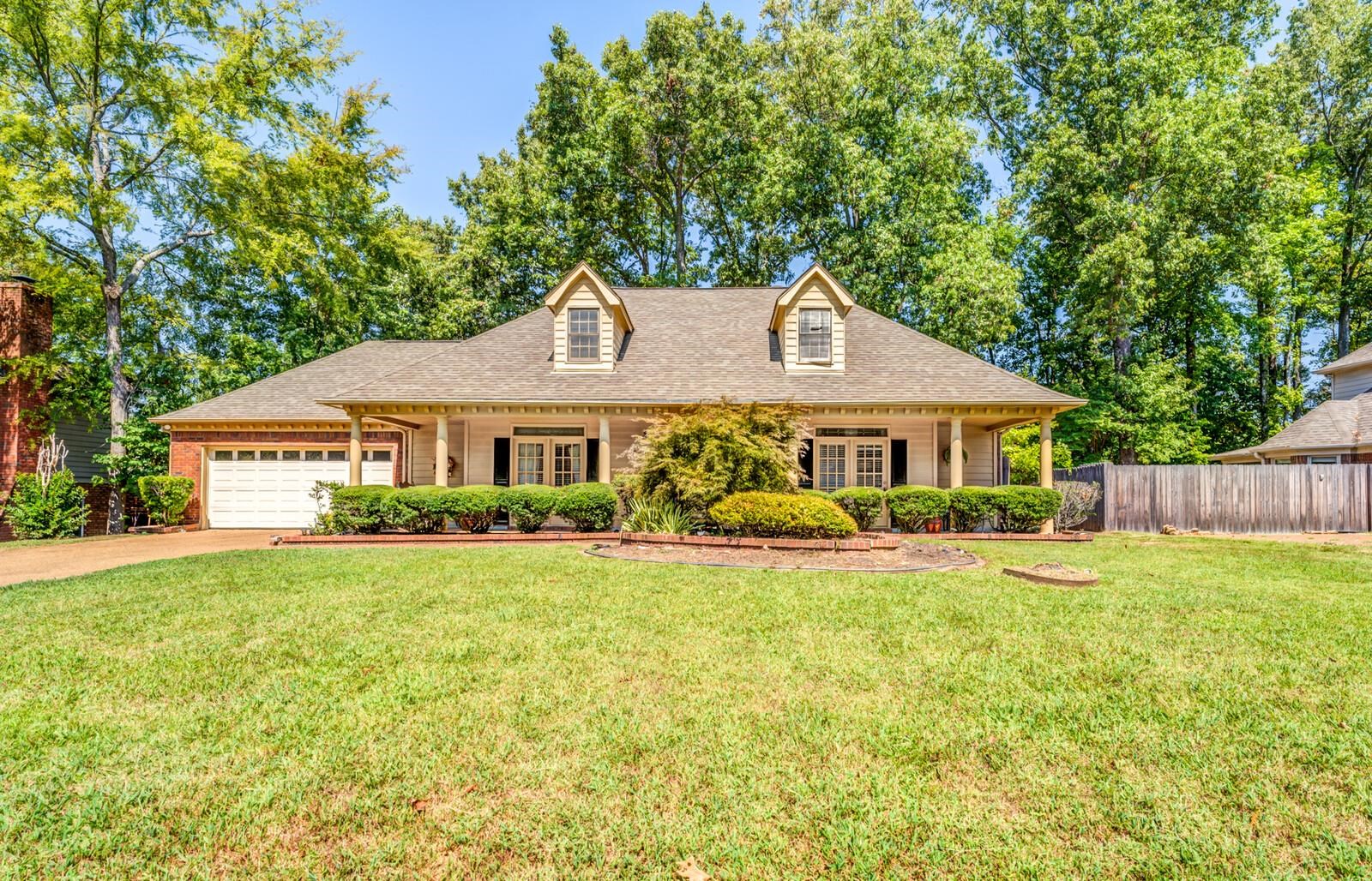 a front view of a house with yard and green space