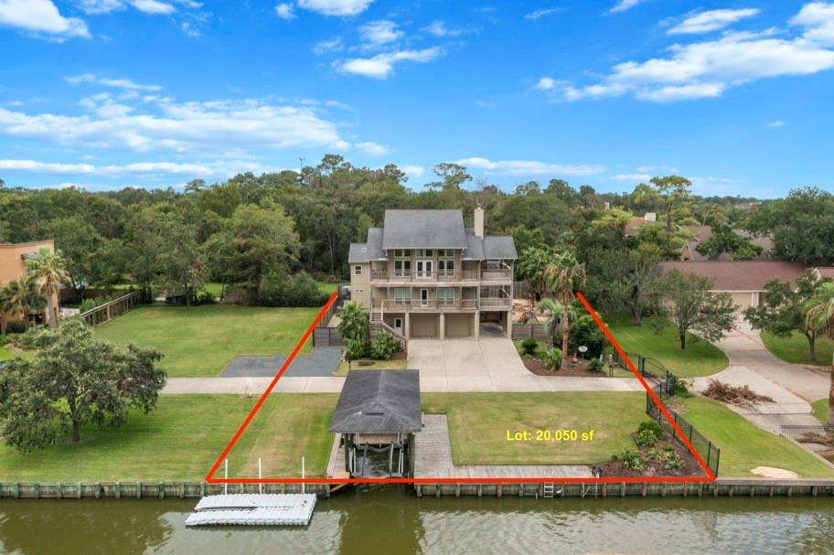 Welcome HOME to 4525 Beacon Hill Dr. in Seabrook! This home sits on a 20,050 sf lot with 4 bedrooms, 3 full bathrooms, 2 half baths, pool, spa, outdoor kitchen and bar and a private guest suite! Here's an aerial view of this multi-story, modern home with easy access to Taylor Lake and comes with a private dock, covered boat lift, in a lush, green setting.