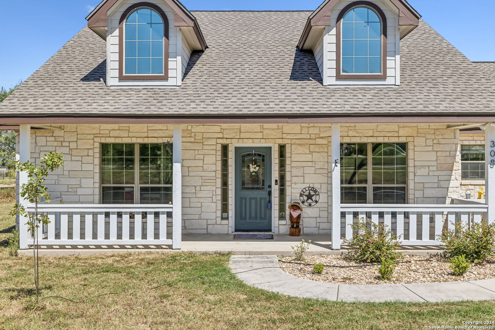 front view of a brick house with a yard