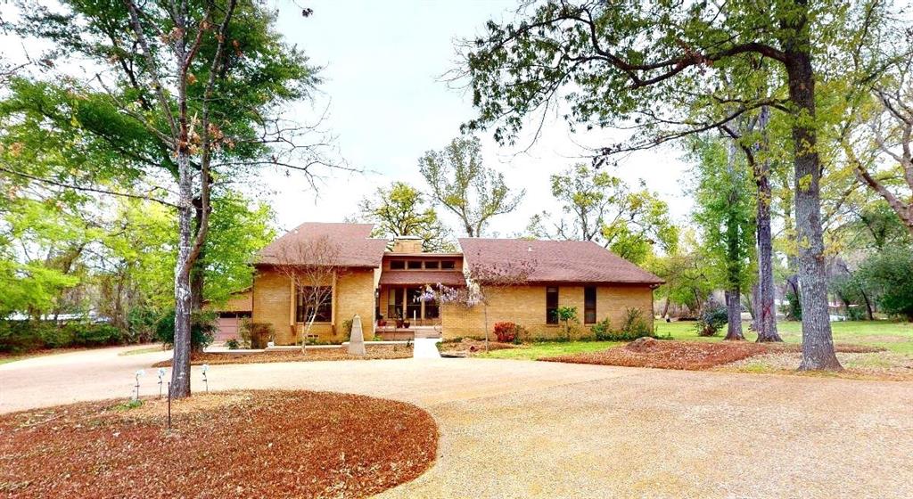 a front view of a house with a yard and trees