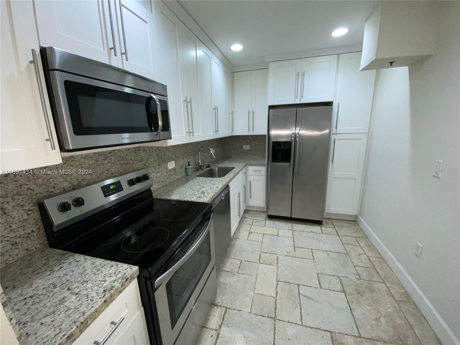 a kitchen with a stove a microwave and a sink