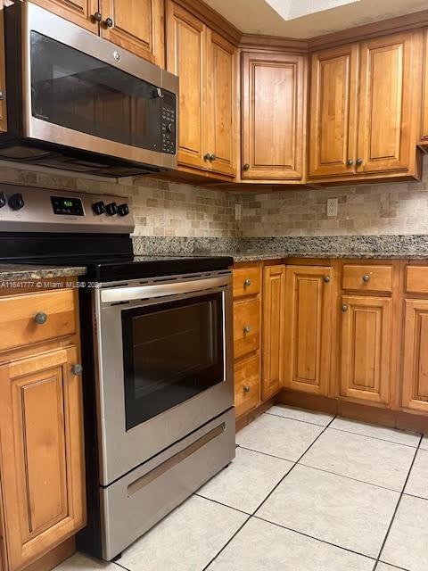 a kitchen with wooden cabinets and a stove top oven