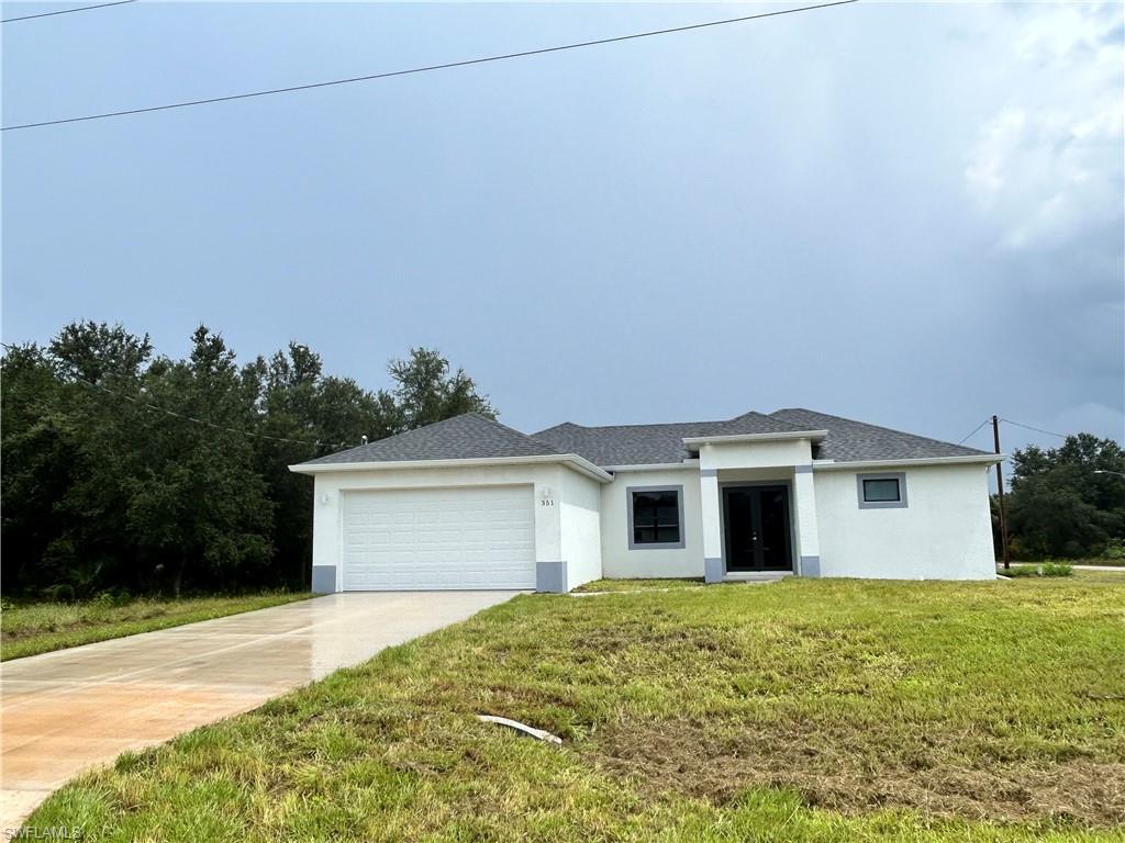 a front view of a house with a yard and garage