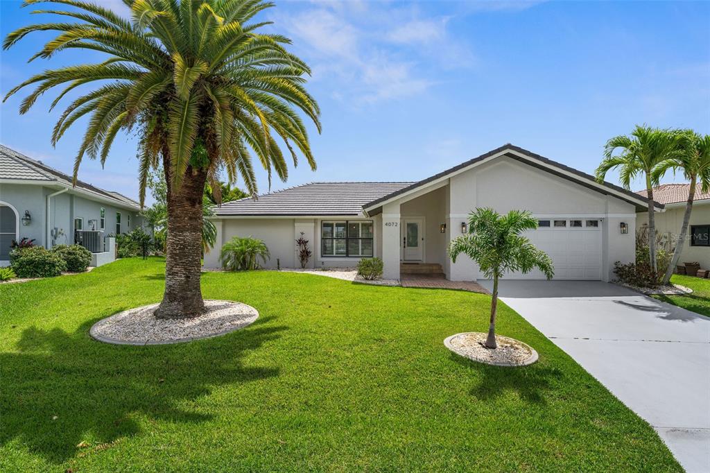 a front view of a house with a yard and palm tree