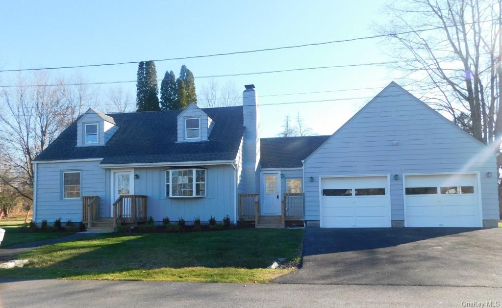 View of front facade featuring a front lawn and a 2 car garage