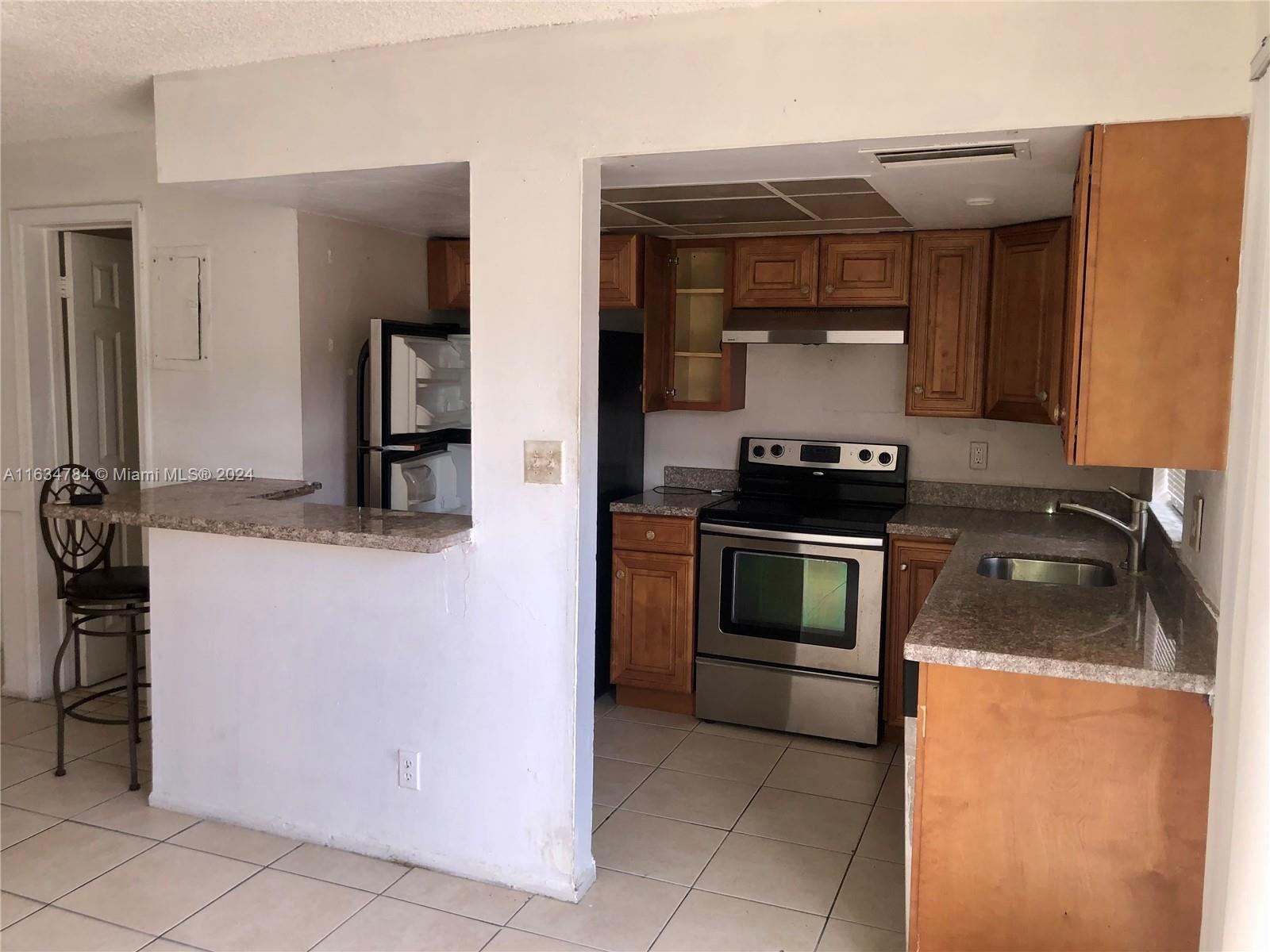 a kitchen with granite countertop a stove and a refrigerator