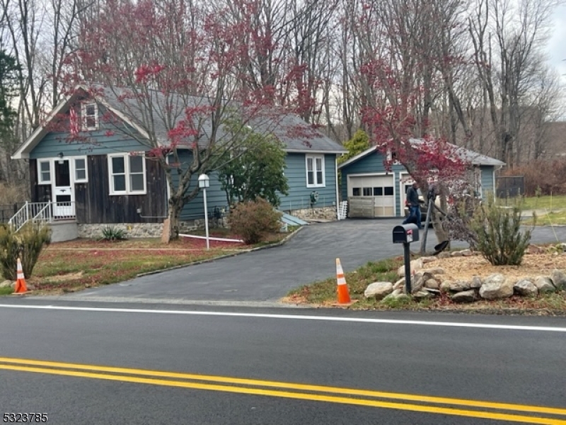 a front view of a house with a yard and trees