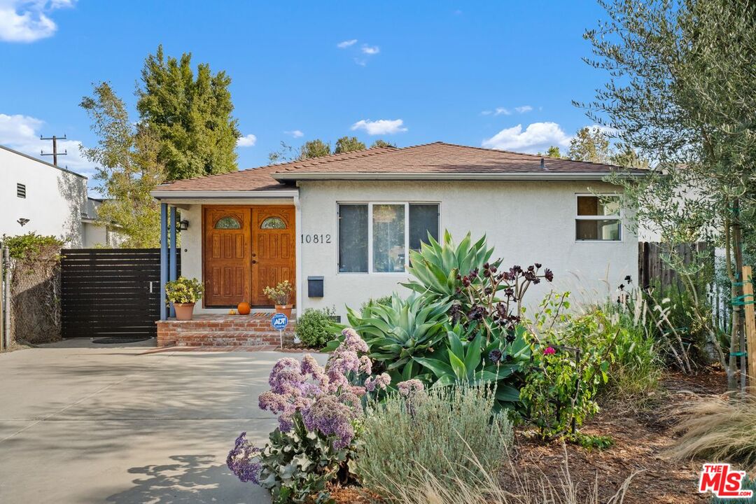 a front view of a house with a garden