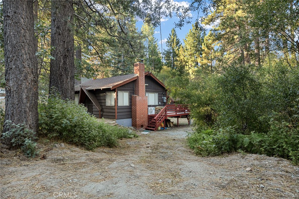 a view of a house with a yard and trees