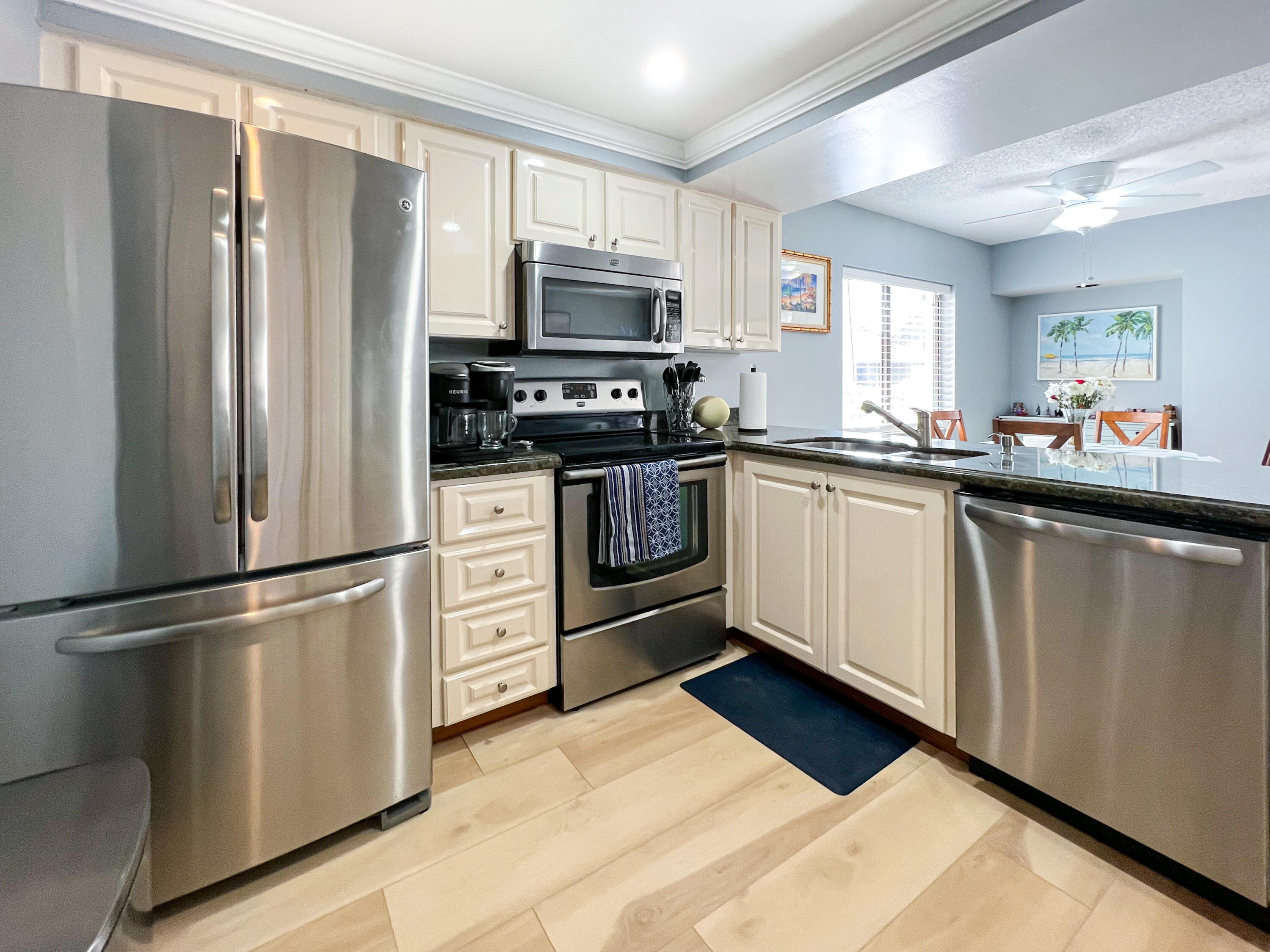 a kitchen with white cabinets stainless steel appliances and a window