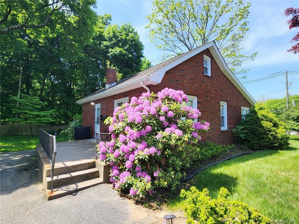 a front view of a house with a yard and fountain