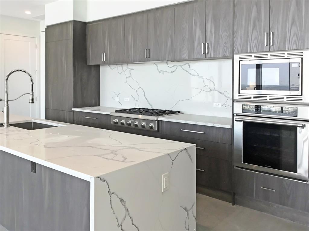 a kitchen with granite countertop a stove and a microwave