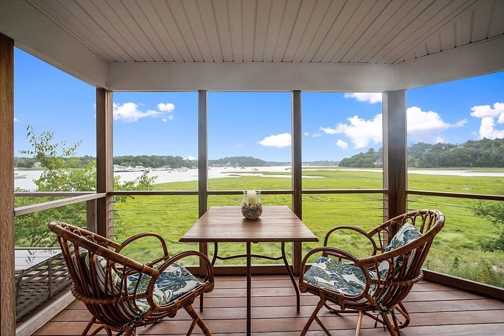 a view of a chairs and table in patio with a yard