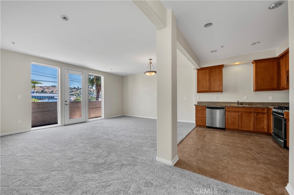 a view of a kitchen with stainless steel appliances granite countertop a refrigerator and a sink