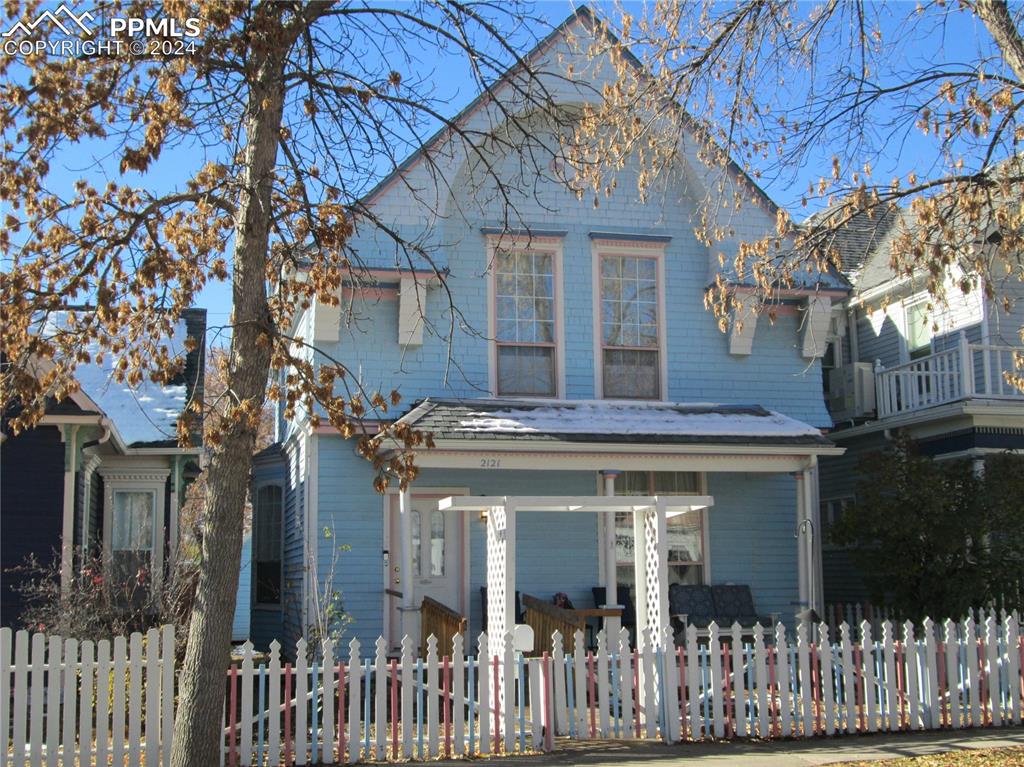 a view of a brick house with iron fence