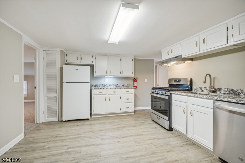 a kitchen with white cabinets and white appliances