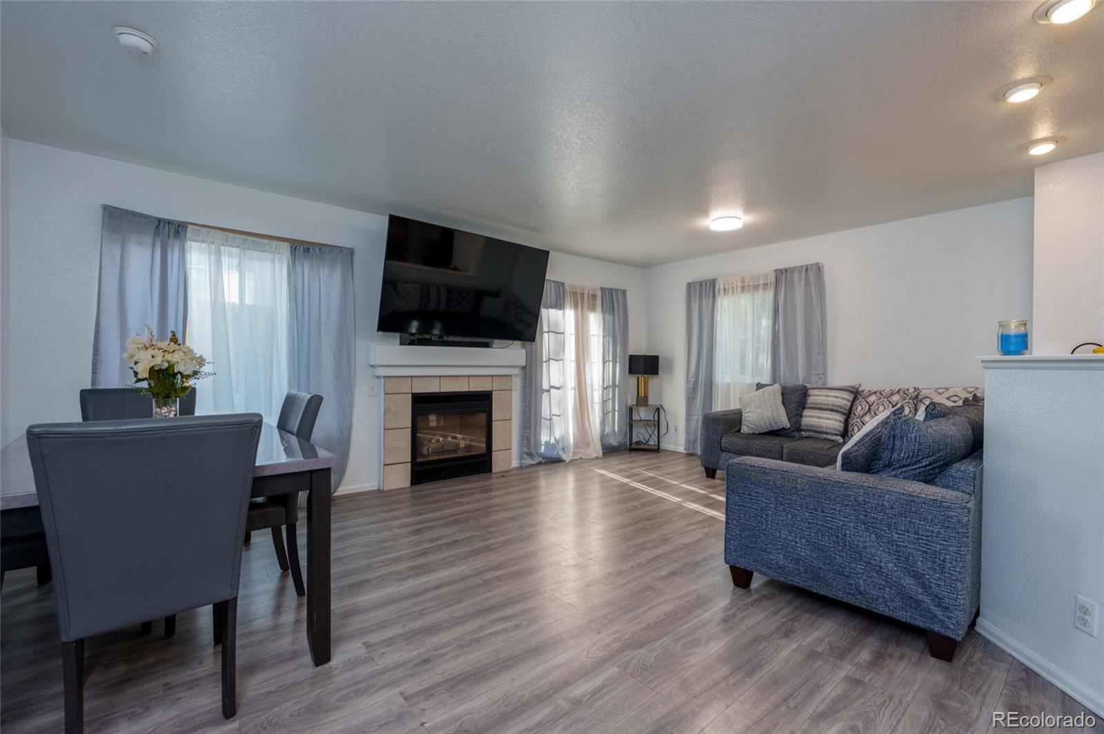 a living room with furniture a flat screen tv and a fireplace