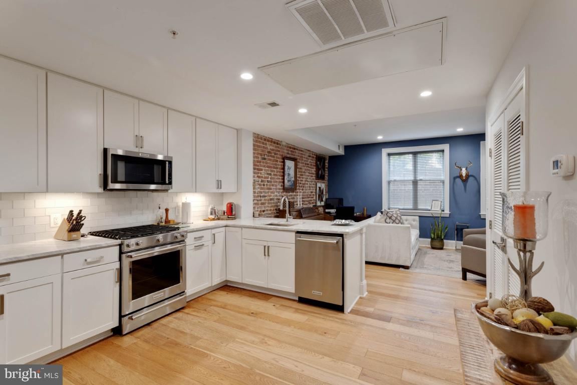 a kitchen with granite countertop stainless steel appliances and white cabinets