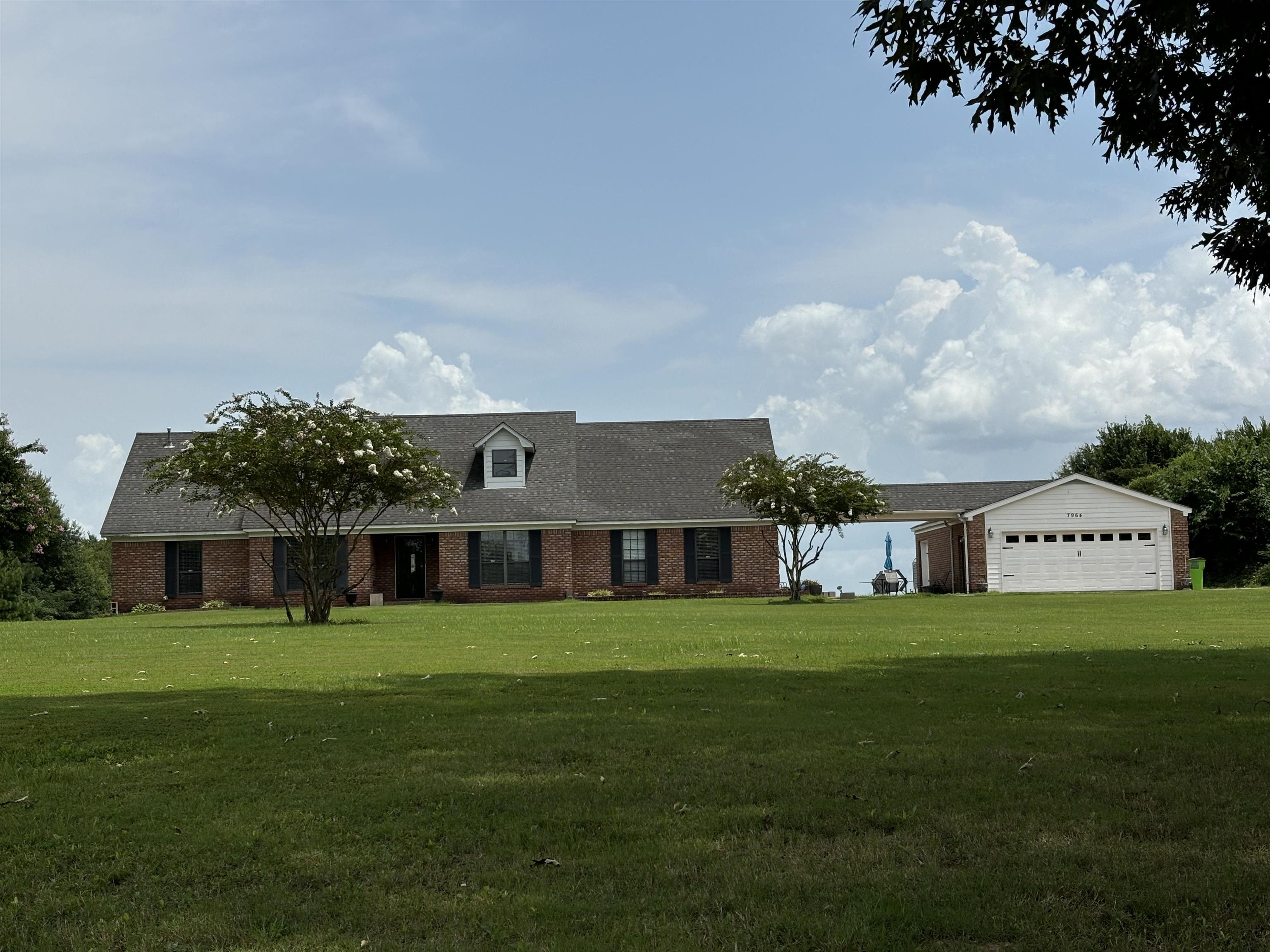 a view of a house with a big yard and large trees